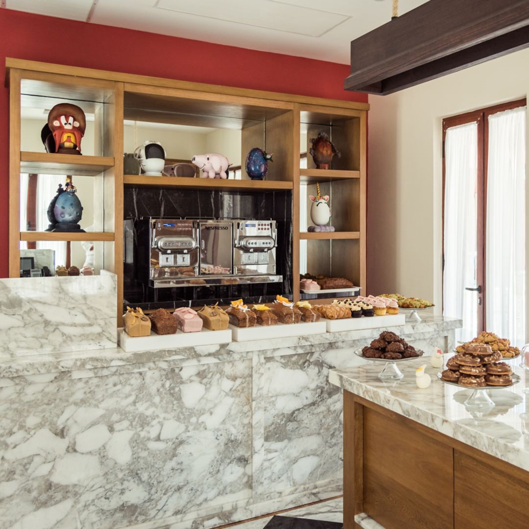 A café with a marble counter displaying  desserts.